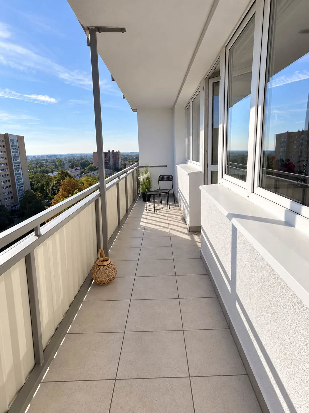 Widok na przestronny balkon z płytkami podłogowymi oraz balustradą w mieszkaniu na sprzedaż w Opolu