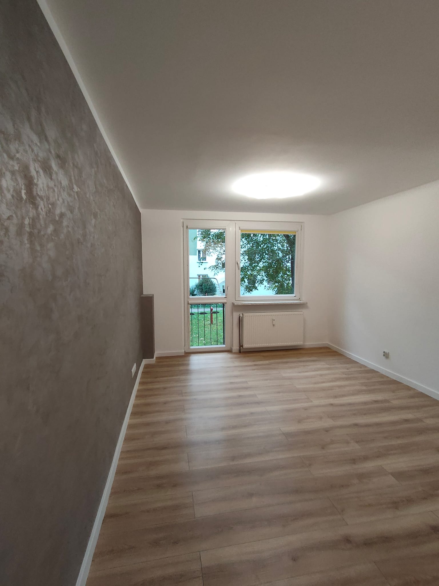 Jasny salon w mieszkaniu na sprzedaż w Opolu przy ulicy Dambonia z wyjściem na balkon