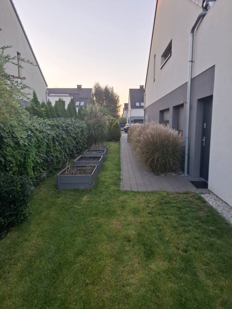 elewacja nowoczesnego budynku mieszkalnego z ogrodem i ścieżką z kostki brukowej w Opolu Chmielowicach
