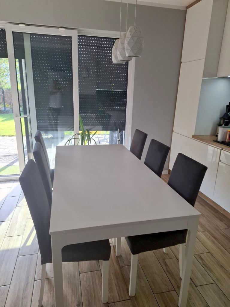 Jasny salon z dużym stołem i krzesłami w mieszkaniu na sprzedaż w Chmielowicach w Opolu