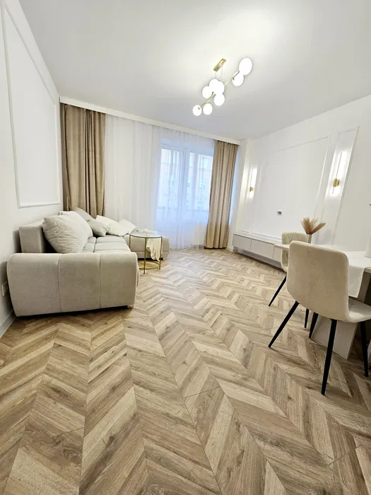 jasny salon w mieszkaniu na sprzedaż w Opolu przy ulicy Powolnego z drewnianą podłogą w jodełkę