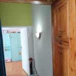 Widok na korytarz i pokój w mieszkaniu w Opolu z drewnianą drzwiami i jasnymi ścianami