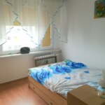 Jasny pokój z łóżkiem i oknem w mieszkaniu na sprzedaż w Prudniku