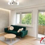 Jasny salon w mieszkaniu na sprzedaż w Opolu z zieloną sofą i wyjściem na balkon