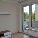 Jasny salon w mieszkaniu na sprzedaż w Opolu z dużymi oknami i wyjściem na balkon