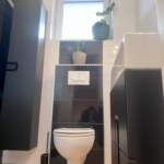 Nowoczesna łazienka w domu wolnostojącym w Chmielowicach z białą ceramiką i czarnymi płytkami