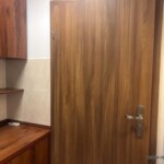 Wnętrze lokalu użytkowe w centrum Opole prezentujące drewniane drzwi oraz zabudowę kuchenną