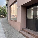 Elewacja i wejście do lokalu użytkowego w centrum Opola z widocznym chodnikiem i dużym oknem