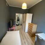 Wynajem pokoju w Opolu z widokiem na umeblowane wnętrze z łóżkiem i szafą