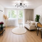 Jasny salon w mieszkaniu na sprzedaż w Opolu z jasną kanapą i stołem