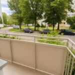 widok z balkonu mieszkania na sprzedaż w Opolu na zielone drzewa i parking
