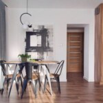 Jasny salon z jadalnią w mieszkaniu w Opolu z drewnianym stołem i czarnymi krzesłami