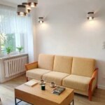 Jasny salon w mieszkaniu w centrum Opola z widoczną żółtą kanapą i stolikiem kawowym