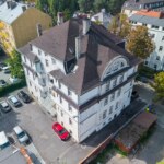 Widok z góry na wielorodzinną kamienicę w Opolu z parkingiem i sąsiadującymi budynkami w tle