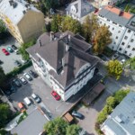 Widok z góry na kamienicę w Opolu z parkingiem i otaczającą zabudową miejską