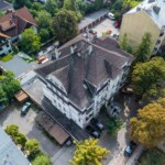 Widok z góry na wielorodzinną kamienicę w Opolu z dachem pokrytym dachówką i otoczeniem zieleni