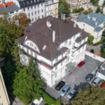 Widok z góry na kamienicę w Opolu z widocznym dachem i parkingiem od podwórka